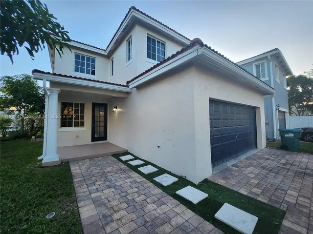 a front view of a house with a yard and a garage