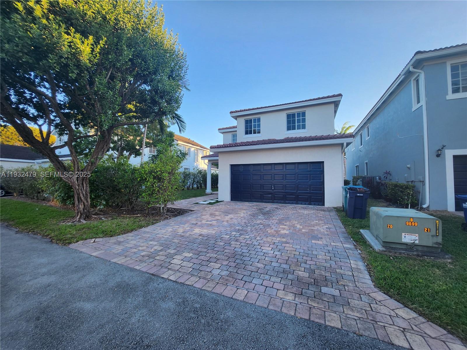 13973 Southwest 276th Way Homestead, FL 33032 - Photo 42 of 43 a front view of a house with a yard and a garage