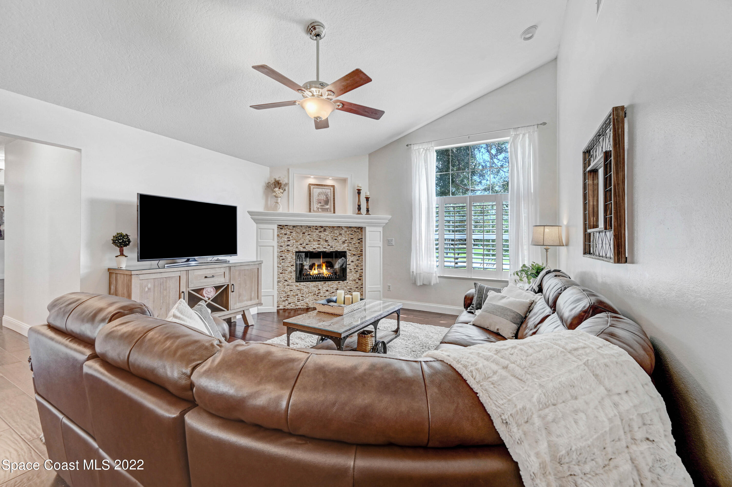 3700 Big Pine Road Melbourne, FL 32934 - Photo 27 of 64 a living room with furniture a flat screen tv and a large window