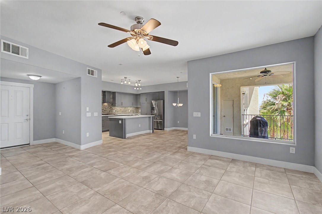 2555 Hampton Road, Unit 6308 Henderson, NV 89052 - Photo 5 of 30 An open-concept living space with kitchen island and a welcoming covered balcony with a ceiling fan for relaxing summer evenings.