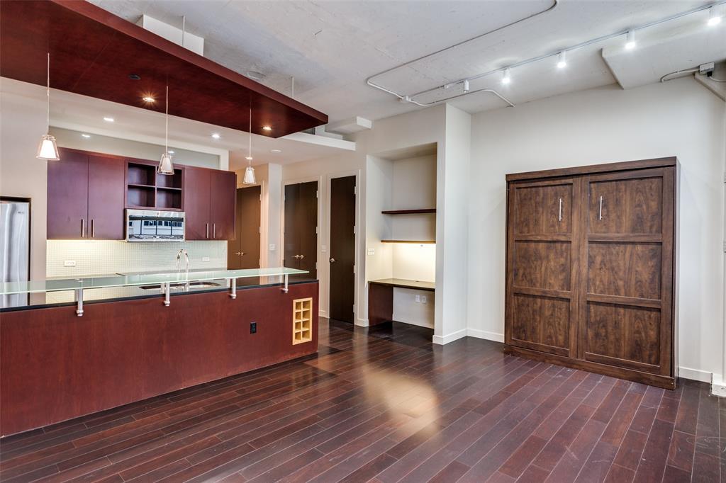 2600 West 7th Street, Unit 1311 Fort Worth, TX 76107 - Photo 10 of 25 a large kitchen with wooden floors and wooden cabinets