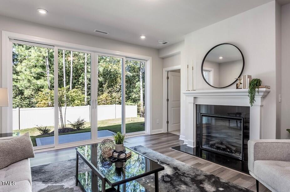 6103 Adecor Way Raleigh, NC 27617 - Photo 14 of 27 a living room with furniture a large window and a fireplace