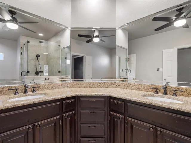 a bathroom with a granite countertop sink two mirror and a