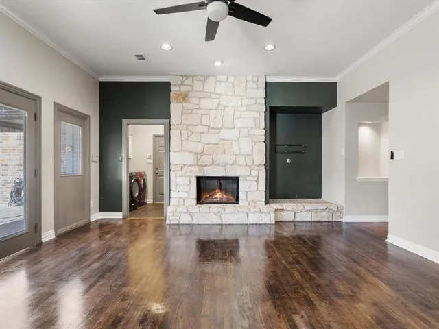 an empty room with wooden floor a fireplace and window