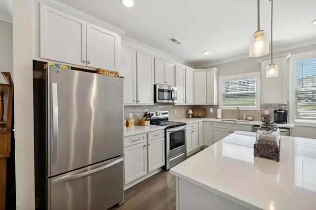 a kitchen with stainless steel appliances granite countertop a refrigerator stove microwave and sink