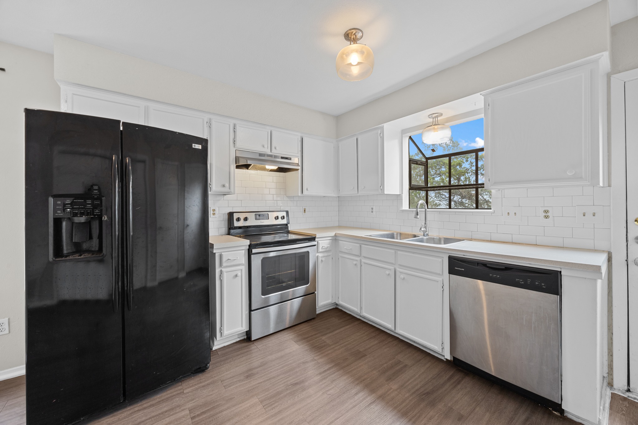 6904 Rifle Bend, Unit A Austin, TX 78736 - Photo 1 of 22 Kitchen with stainless steel appliances, light countertops, white cabinetry, and dark wood-style floors