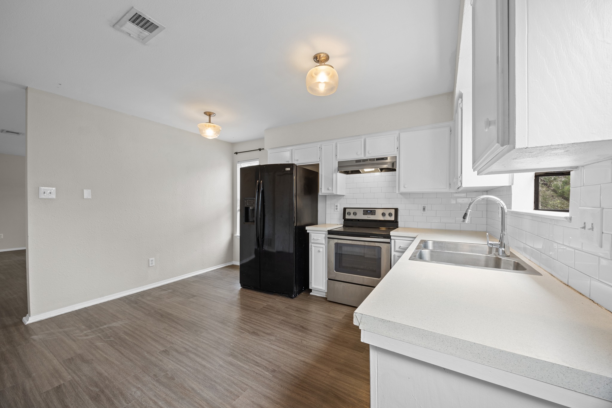 6904 Rifle Bend, Unit A Austin, TX 78736 - Photo 11 of 22 Kitchen with light countertops, electric range, white cabinetry, and black fridge