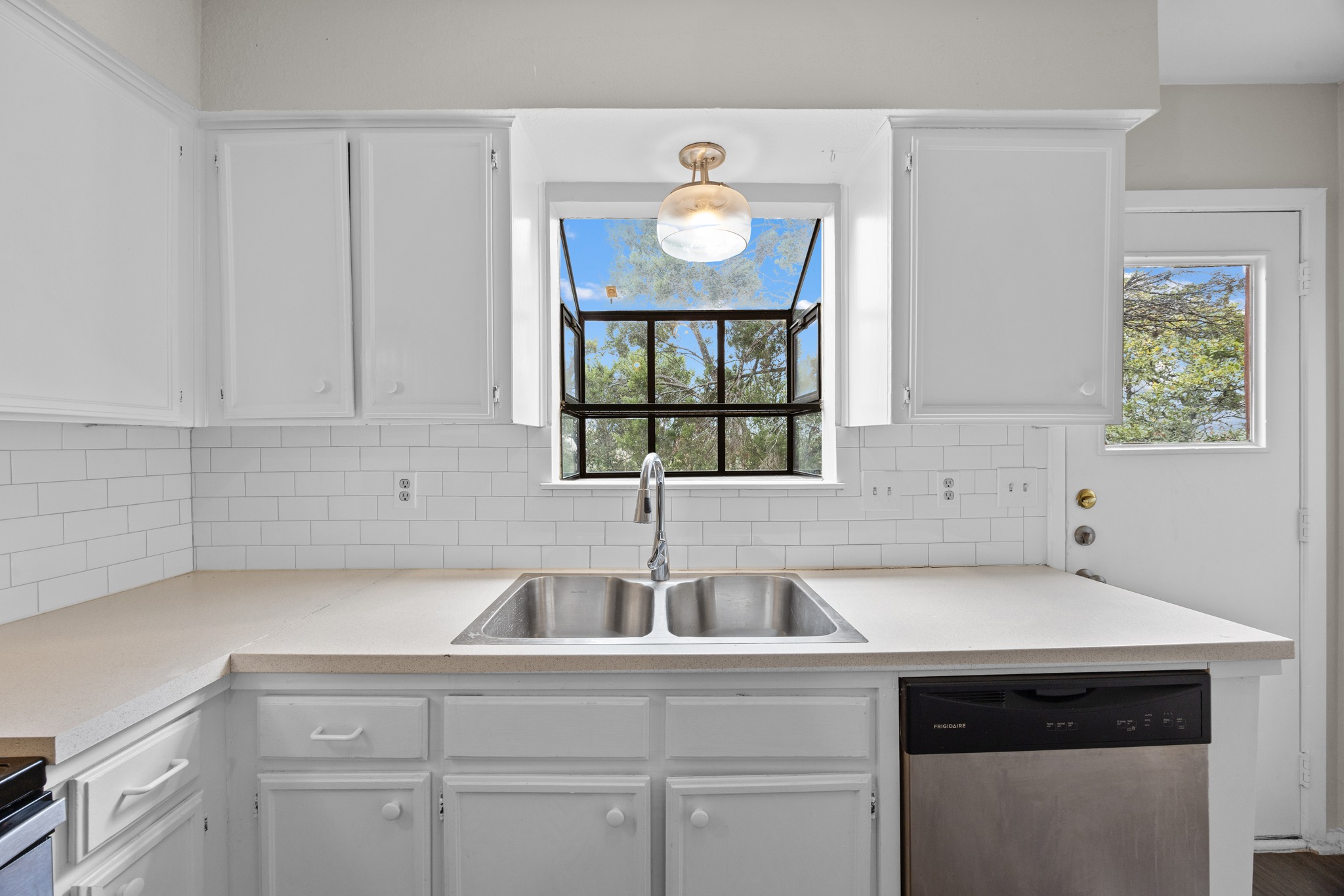 6904 Rifle Bend, Unit A Austin, TX 78736 - Photo 12 of 22 Kitchen with stainless steel dishwasher and white cabinetry