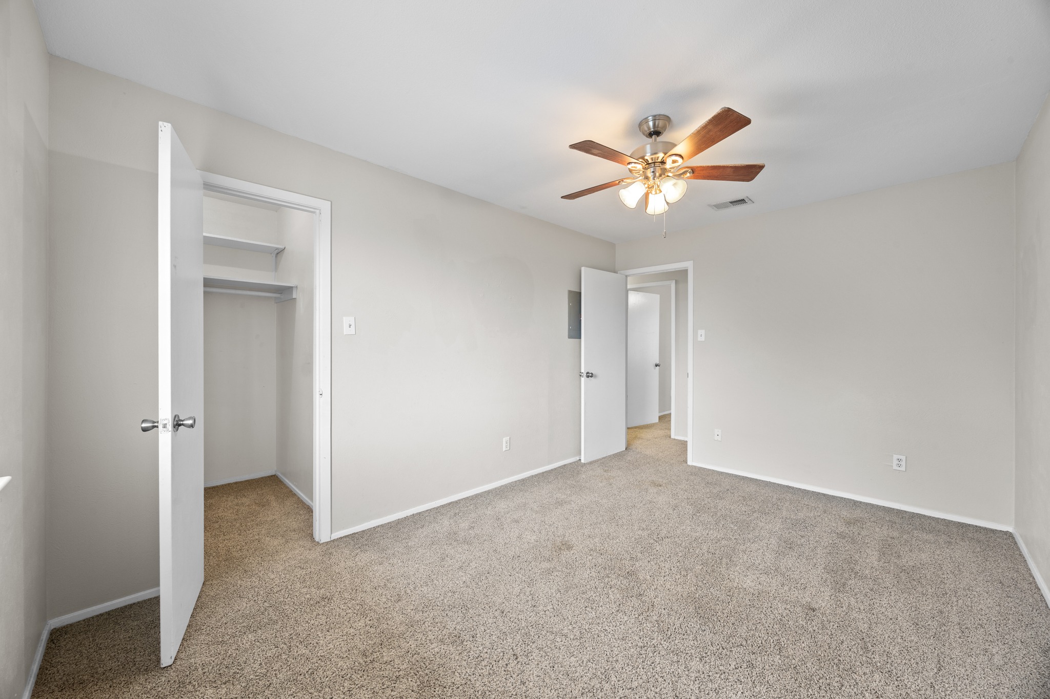 6904 Rifle Bend, Unit A Austin, TX 78736 - Photo 19 of 22 Unfurnished bedroom with a walk in closet, light carpet, and ceiling fan