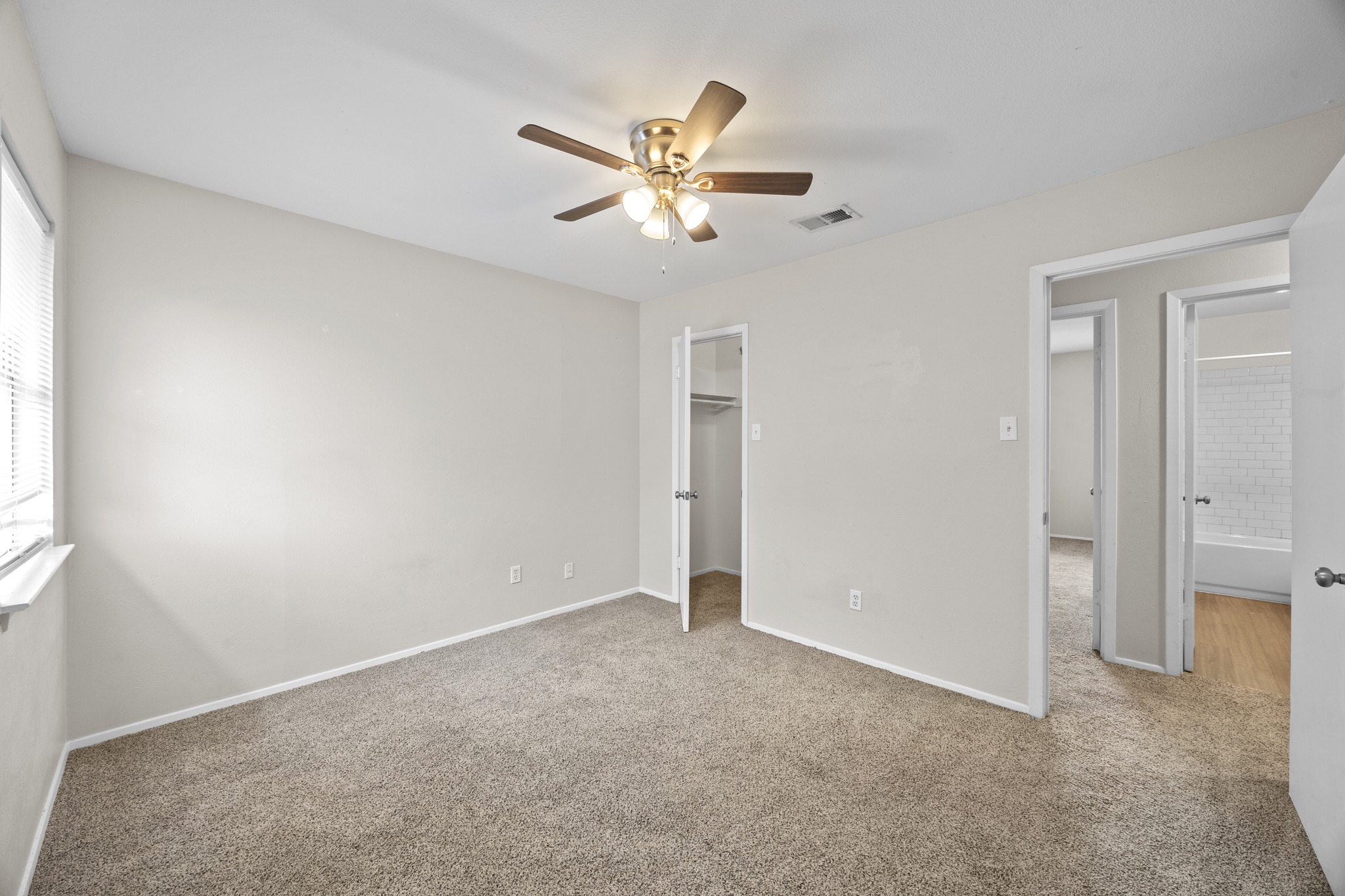 6904 Rifle Bend, Unit A Austin, TX 78736 - Photo 21 of 22 Unfurnished bedroom with a walk in closet, carpet, and ceiling fan