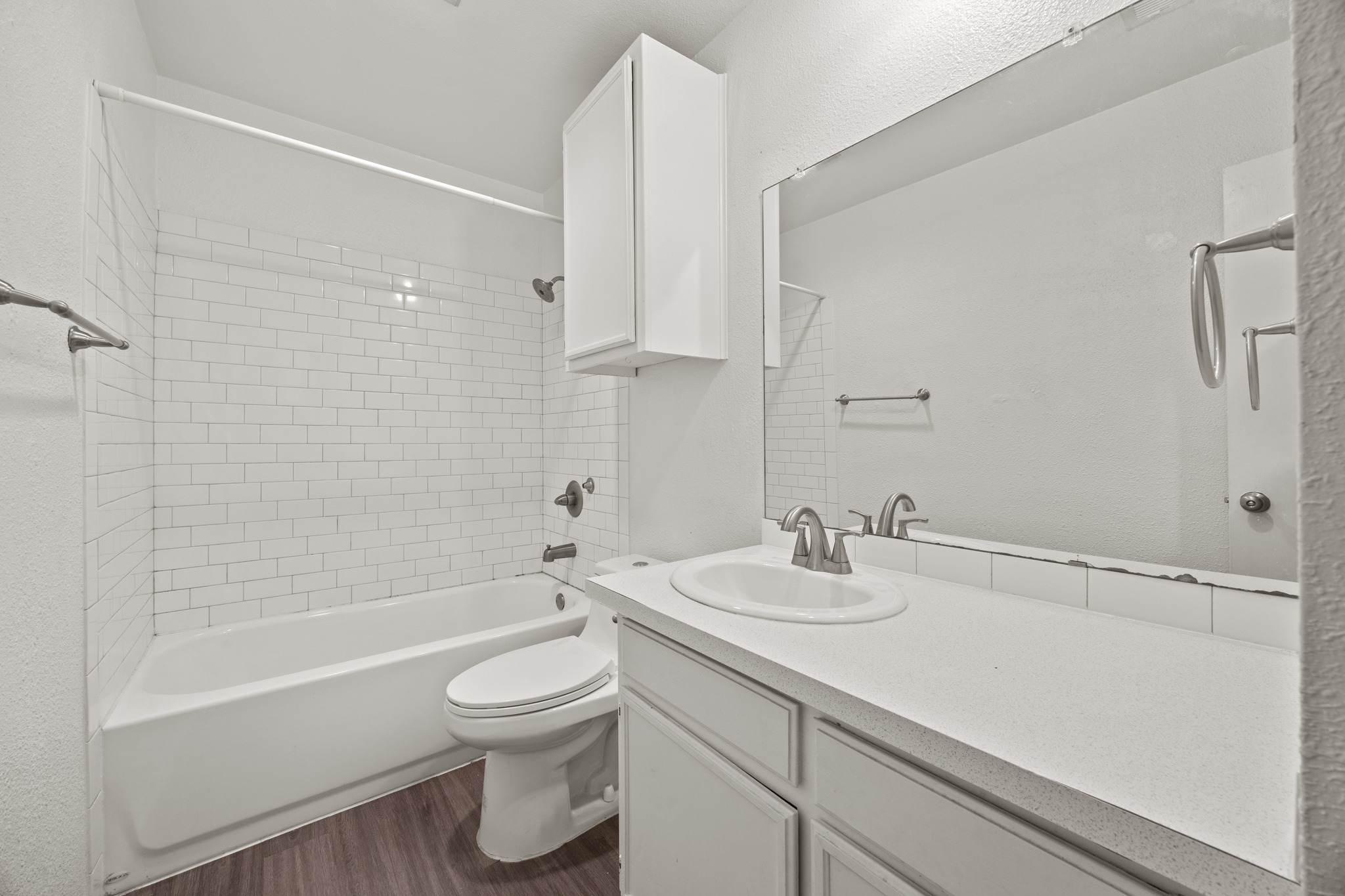 6904 Rifle Bend, Unit A Austin, TX 78736 - Photo 22 of 22 Full bath with vanity, dark wood finished floors, shower / bathtub combination, and a textured wall