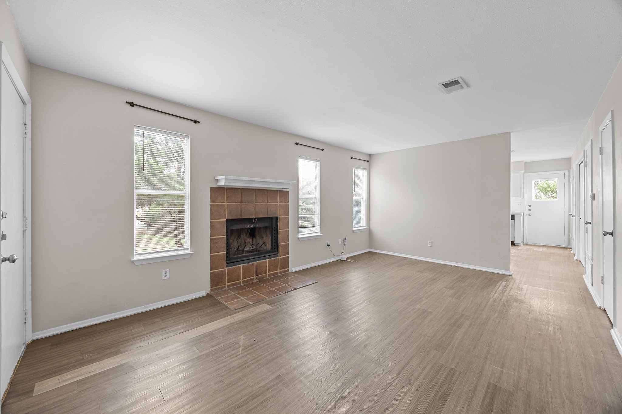 6904 Rifle Bend, Unit A Austin, TX 78736 - Photo 7 of 22 Unfurnished living room featuring wood finished floors and a tile fireplace