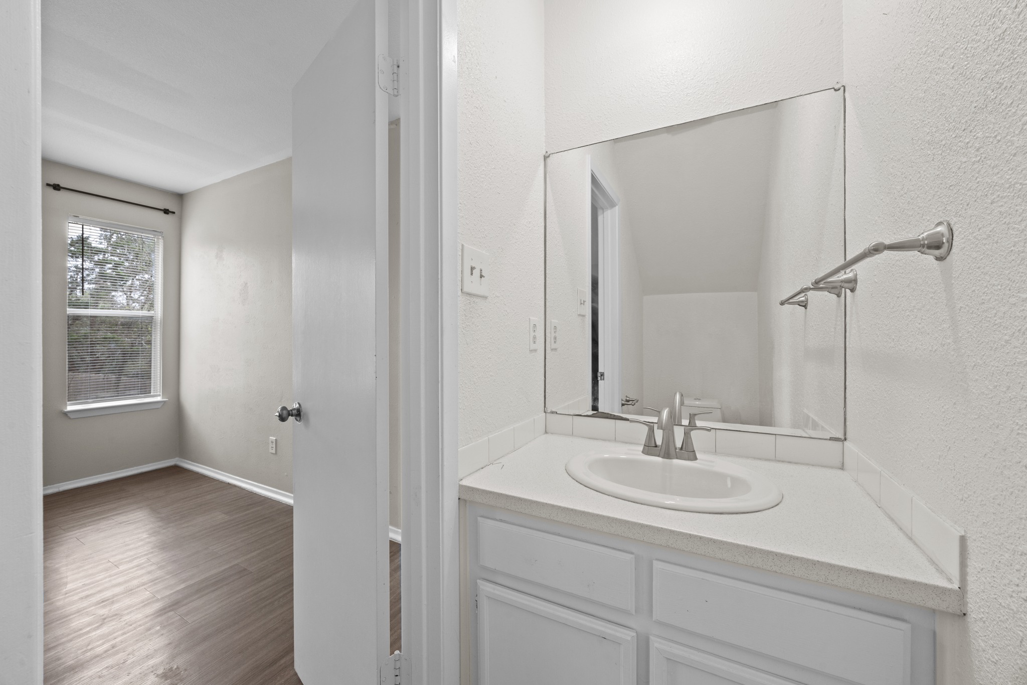 6904 Rifle Bend, Unit A Austin, TX 78736 - Photo 9 of 22 Bathroom with vanity, dark wood-type flooring, and a textured wall