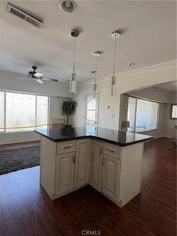 a kitchen with stainless steel appliances granite countertop a sink a stove a refrigerator and wooden floor