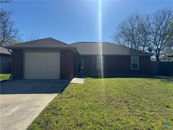 a front view of house with yard and garage