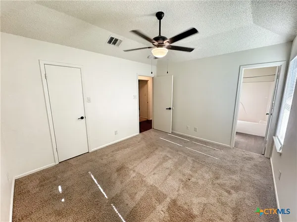 a view of a big room with wooden floor and a ceiling fan
