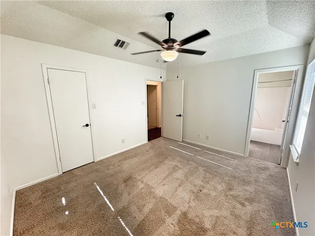a view of a big room with wooden floor and a ceiling fan
