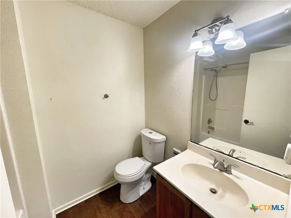 a bathroom with a sink mirror and toilet