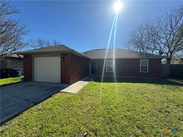 a house with green field in front of it