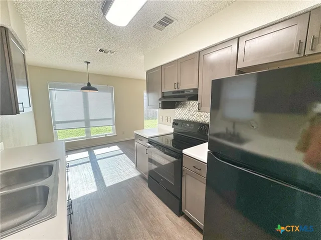 a large kitchen with a large window and stainless steel appliances