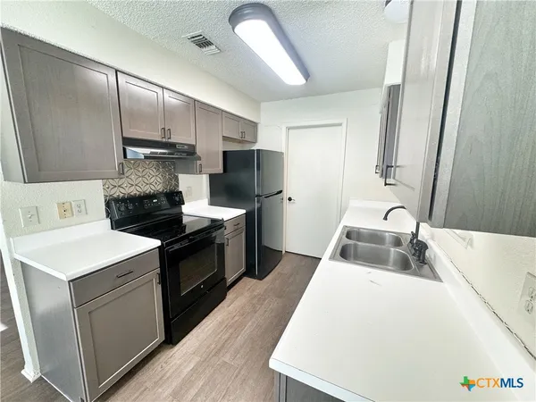 a kitchen with a sink a stove and refrigerator