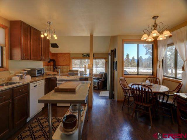 a kitchen with granite countertop a dining table chairs stainless steel appliances and cabinets