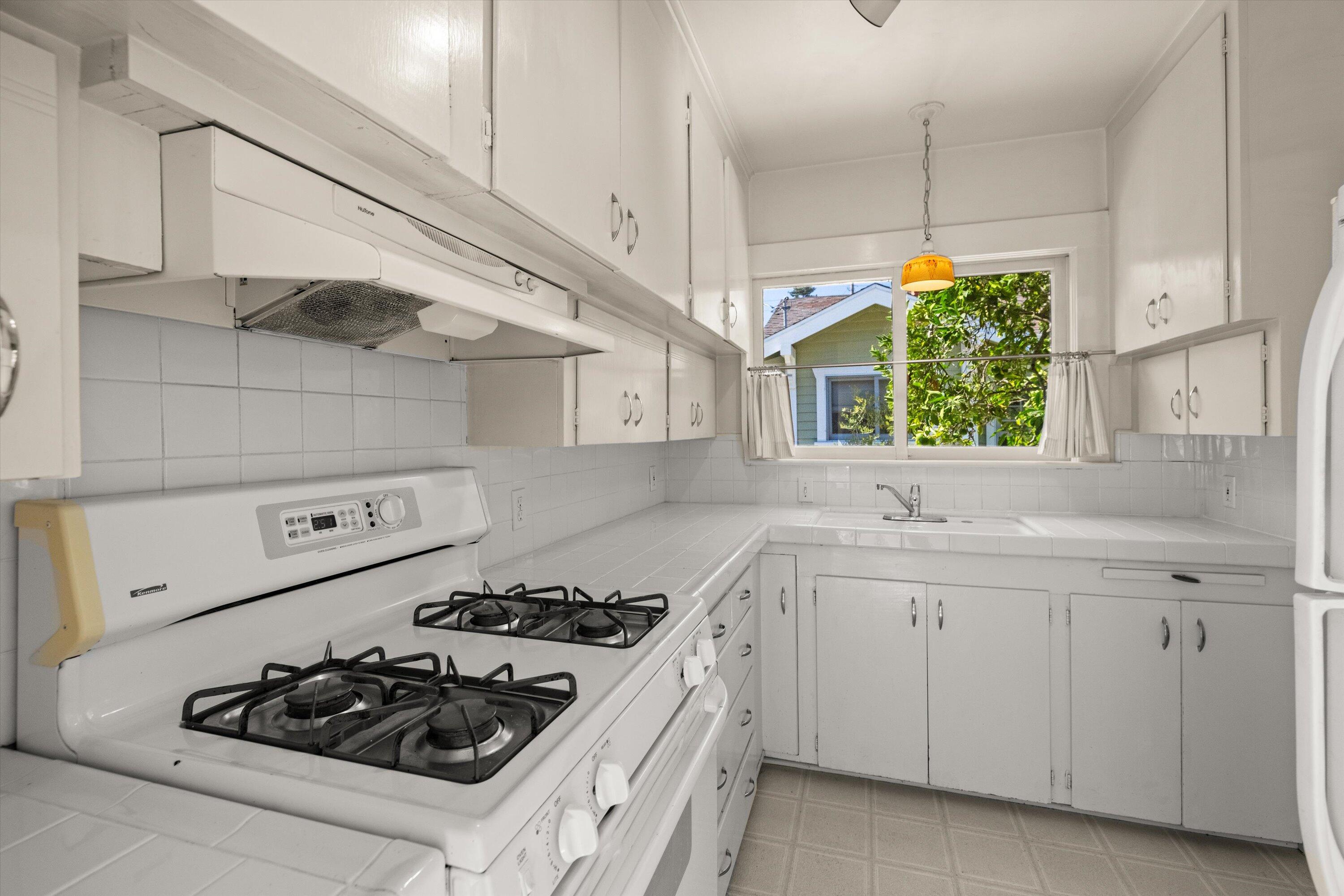 1620 De La Vina Street Santa Barbara, CA 93101 - Photo 30 of 46 a kitchen with white cabinets and appliances