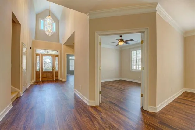 a view of a hallway with wooden floor and a living room