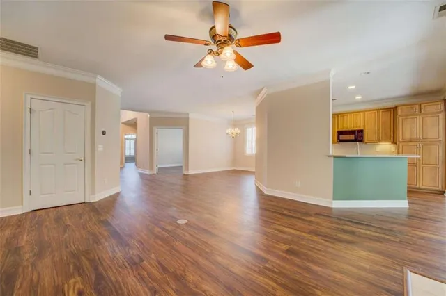 a view of a kitchen with wooden floor and a ceiling fan