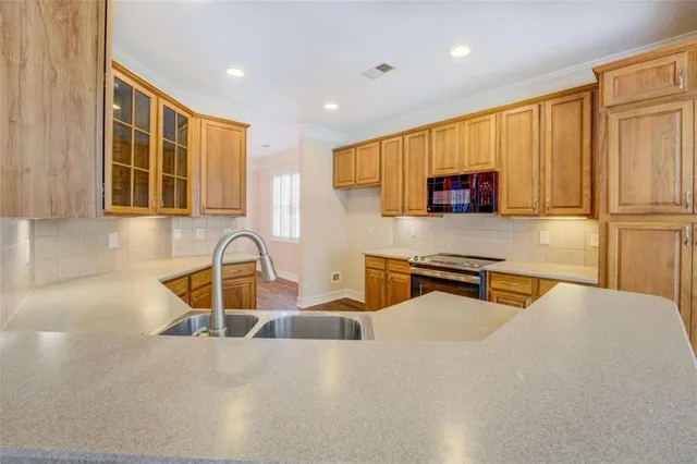 a kitchen with stainless steel appliances granite countertop a sink a stove and a microwave