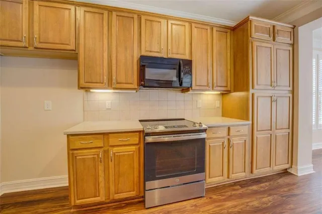 a kitchen with stainless steel appliances granite countertop cabinets and a stove top oven