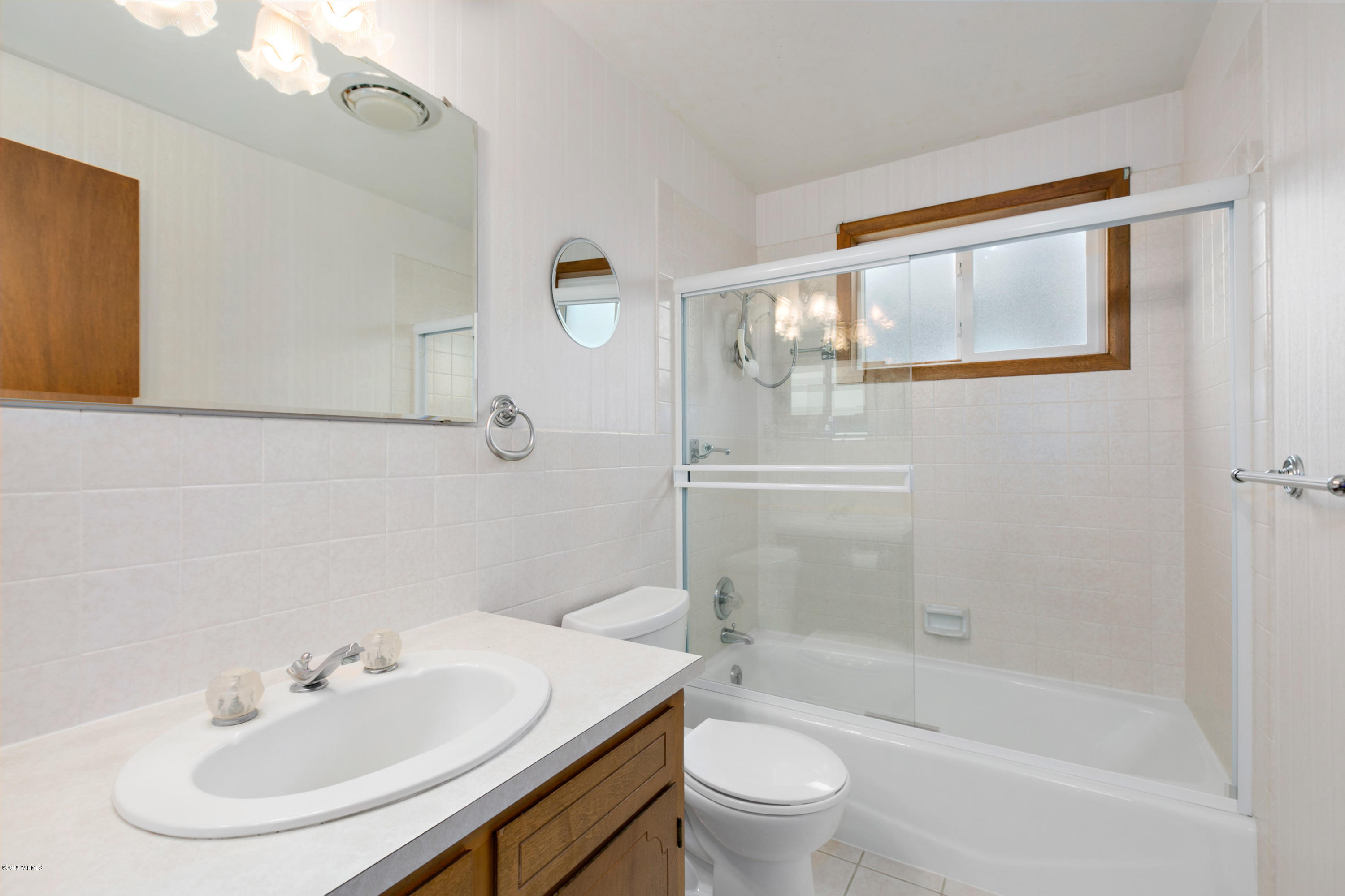 511 South Hennessy Road Yakima, WA 98908 - Photo 13 of 26 a bathroom with a sink mirror and a bathtub