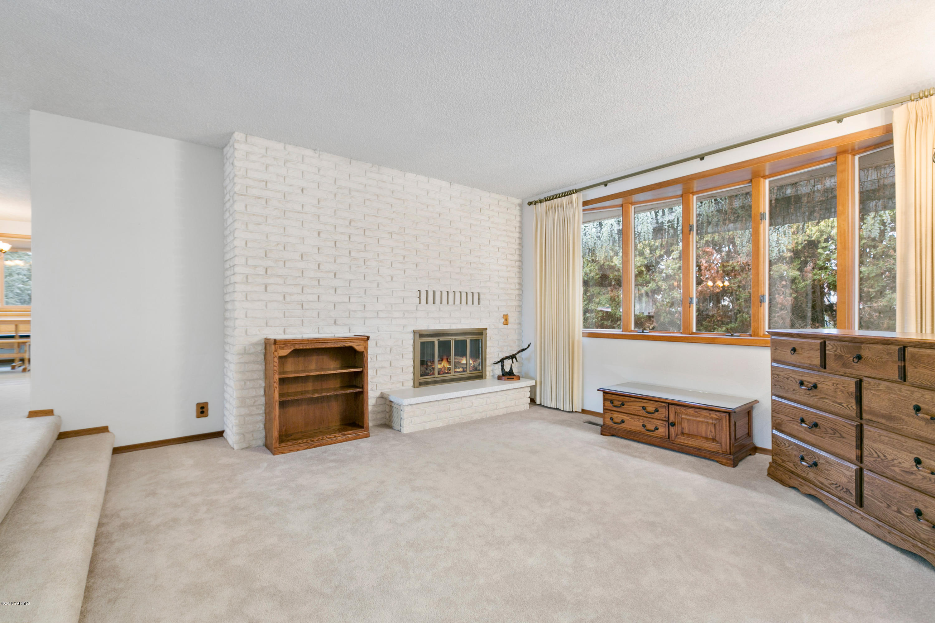 511 South Hennessy Road Yakima, WA 98908 - Photo 3 of 26 an empty room with furniture and a fireplace