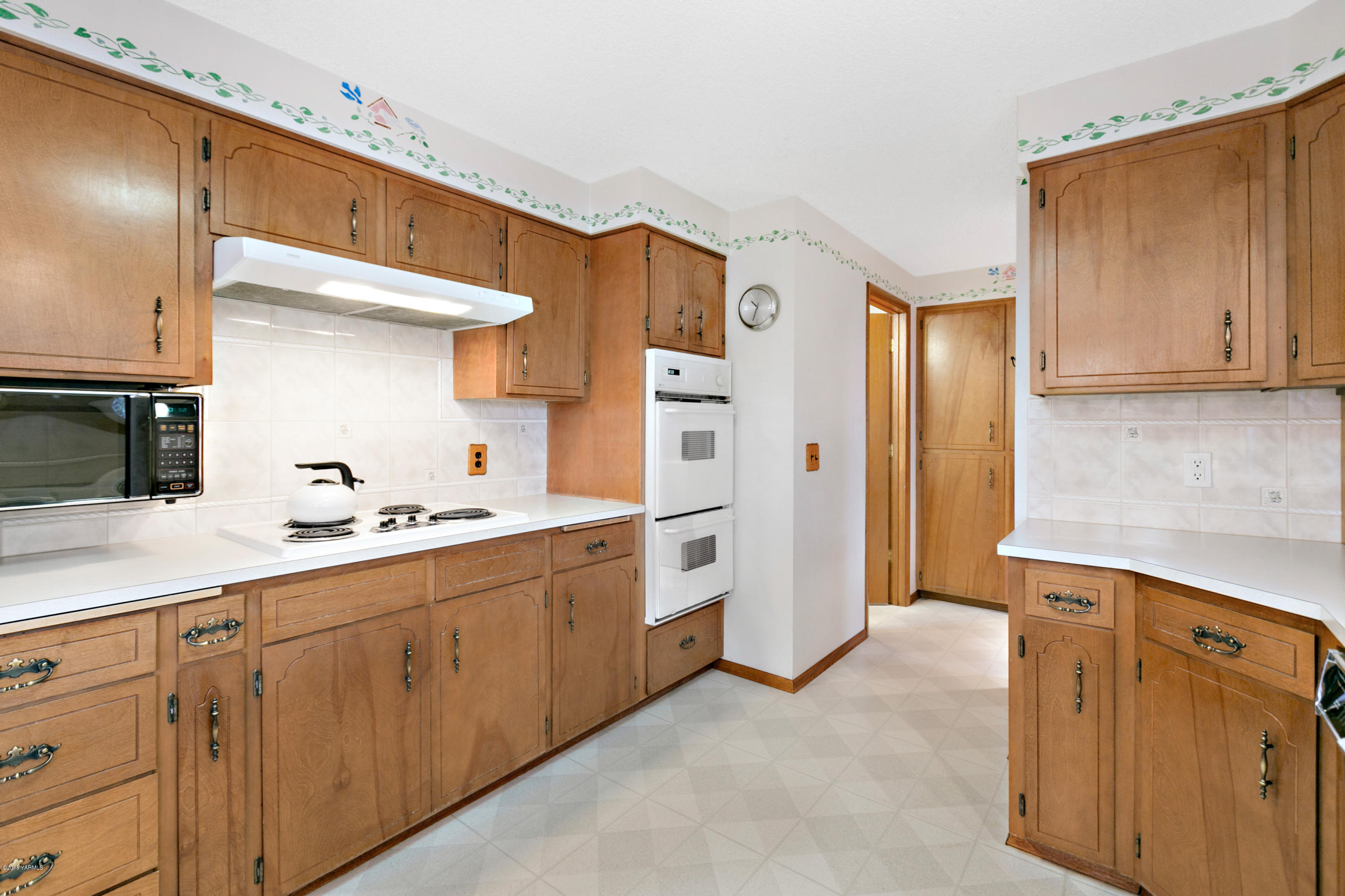 511 South Hennessy Road Yakima, WA 98908 - Photo 8 of 26 a kitchen with cabinets and white appliances