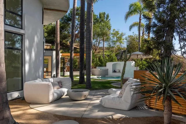 a view of a patio with couches table and chairs and potted plants