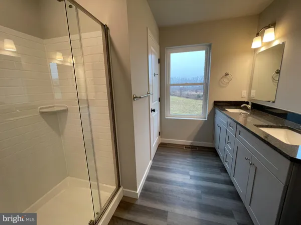 a bathroom with a granite countertop shower a sink and a mirror