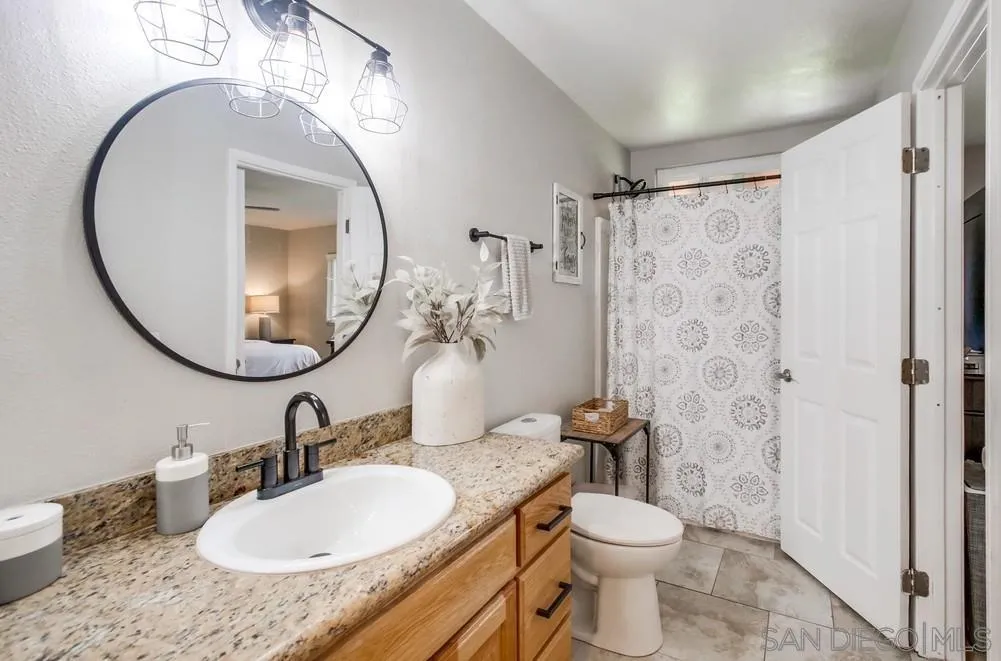 9118 Gotta Place Lakeside, CA 92040 - Photo 33 of 50 a bathroom with a granite countertop toilet sink and mirror