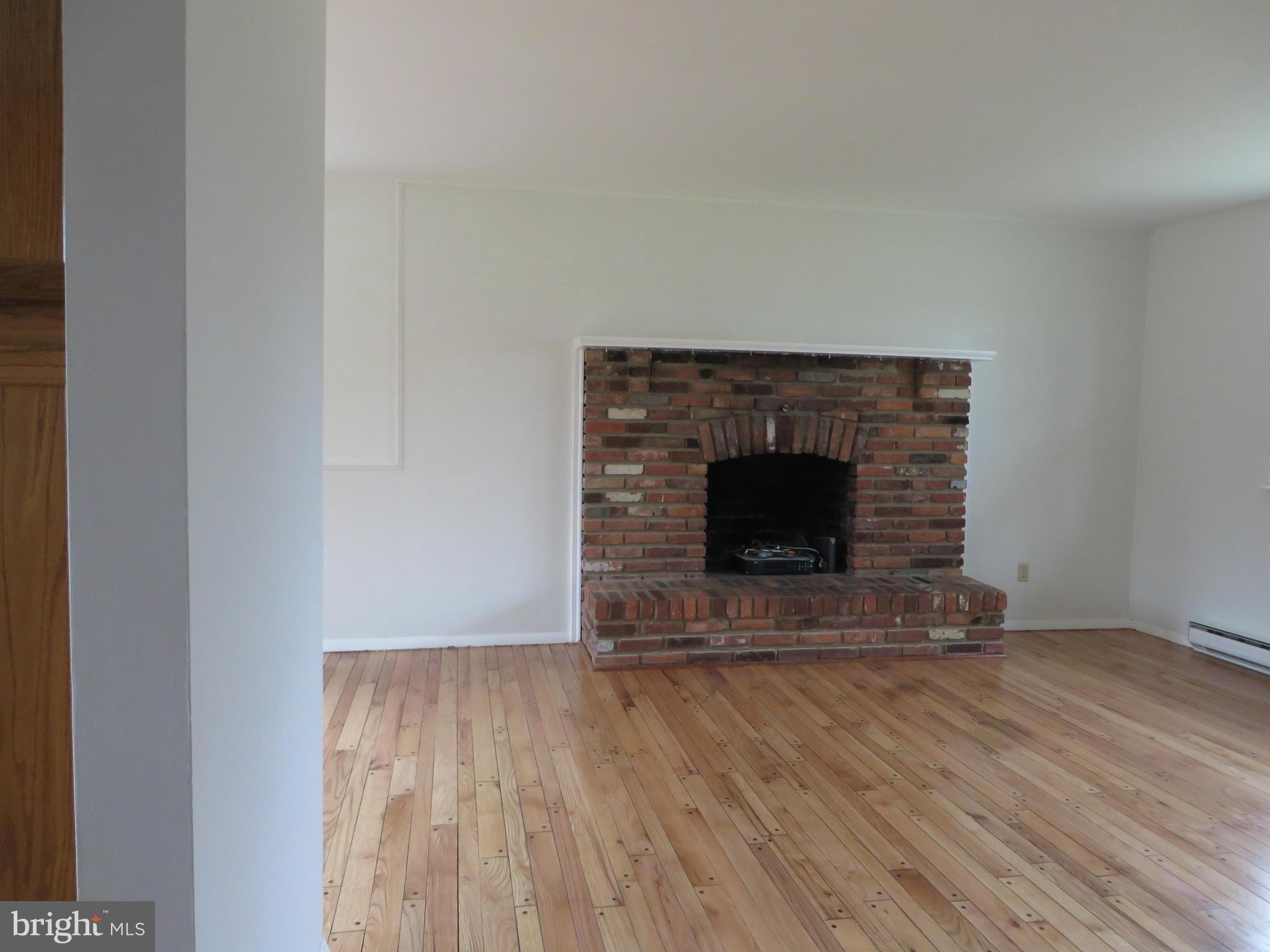 4101 Baptist Road Taneytown, MD 21787 - Photo 9 of 30 a view of an empty room with wooden floor and a fireplace