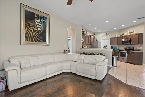 a living room with stainless steel appliances kitchen island furniture and wooden floor