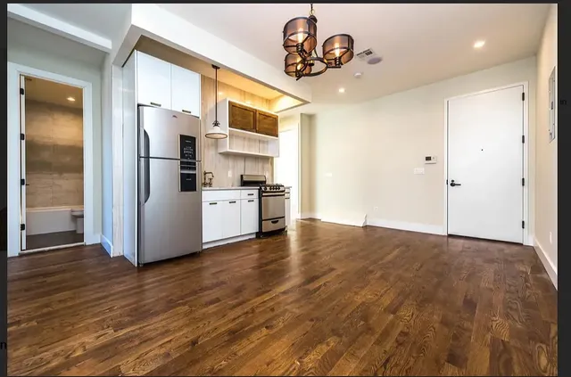 a view of a kitchen with a sink and refrigerator
