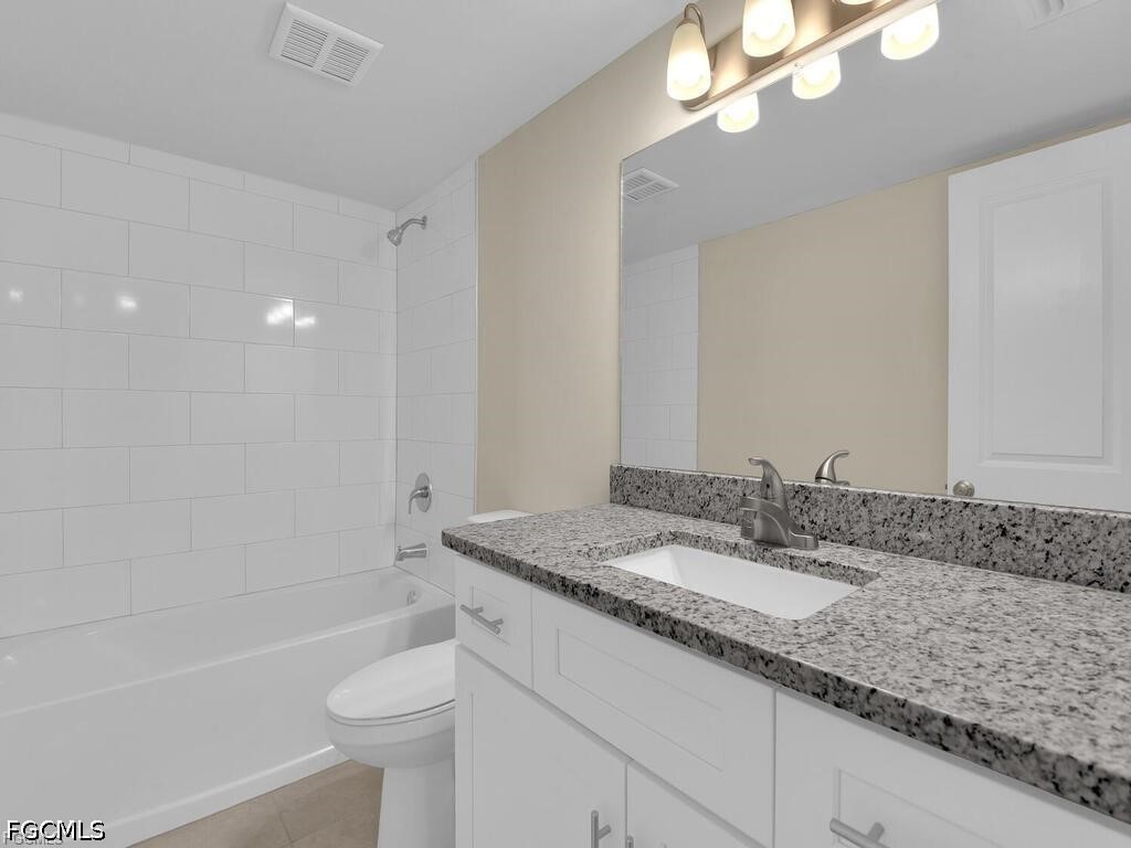 16560 Partridge Place Road, Unit 101 Fort Myers, FL 33908 - Photo 18 of 27 a bathroom with a granite countertop bathtub sink vanity mirror and toilet