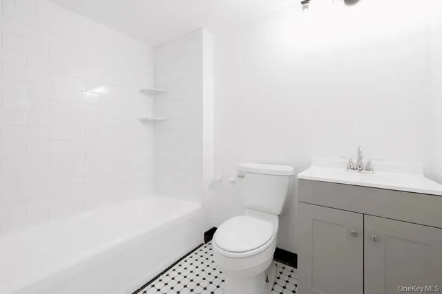 a white toilet sitting next to a bath tub