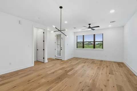 a living room with furniture kitchen view and a wooden floor