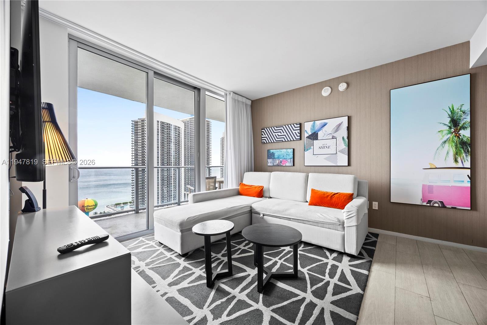 a living room with furniture and a floor to ceiling window