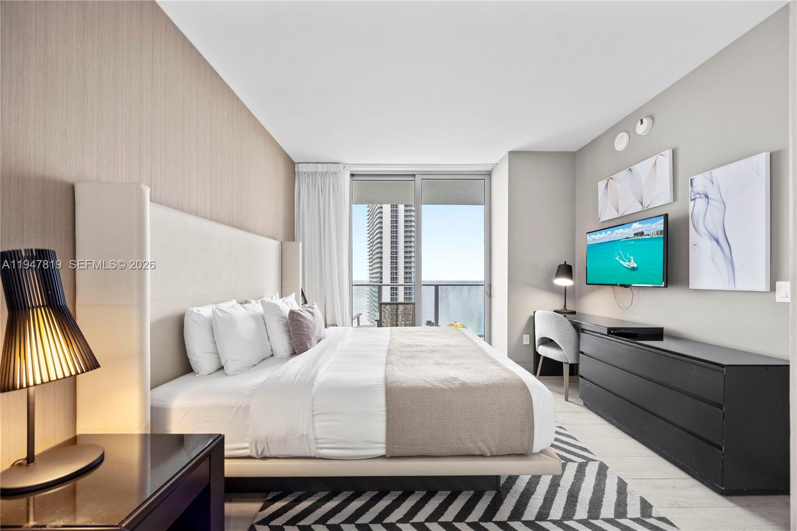 4010 South Ocean Drive, Unit R2307 Hollywood, FL 33019 - Photo 20 of 35 a bedroom with a bed and flat screen tv