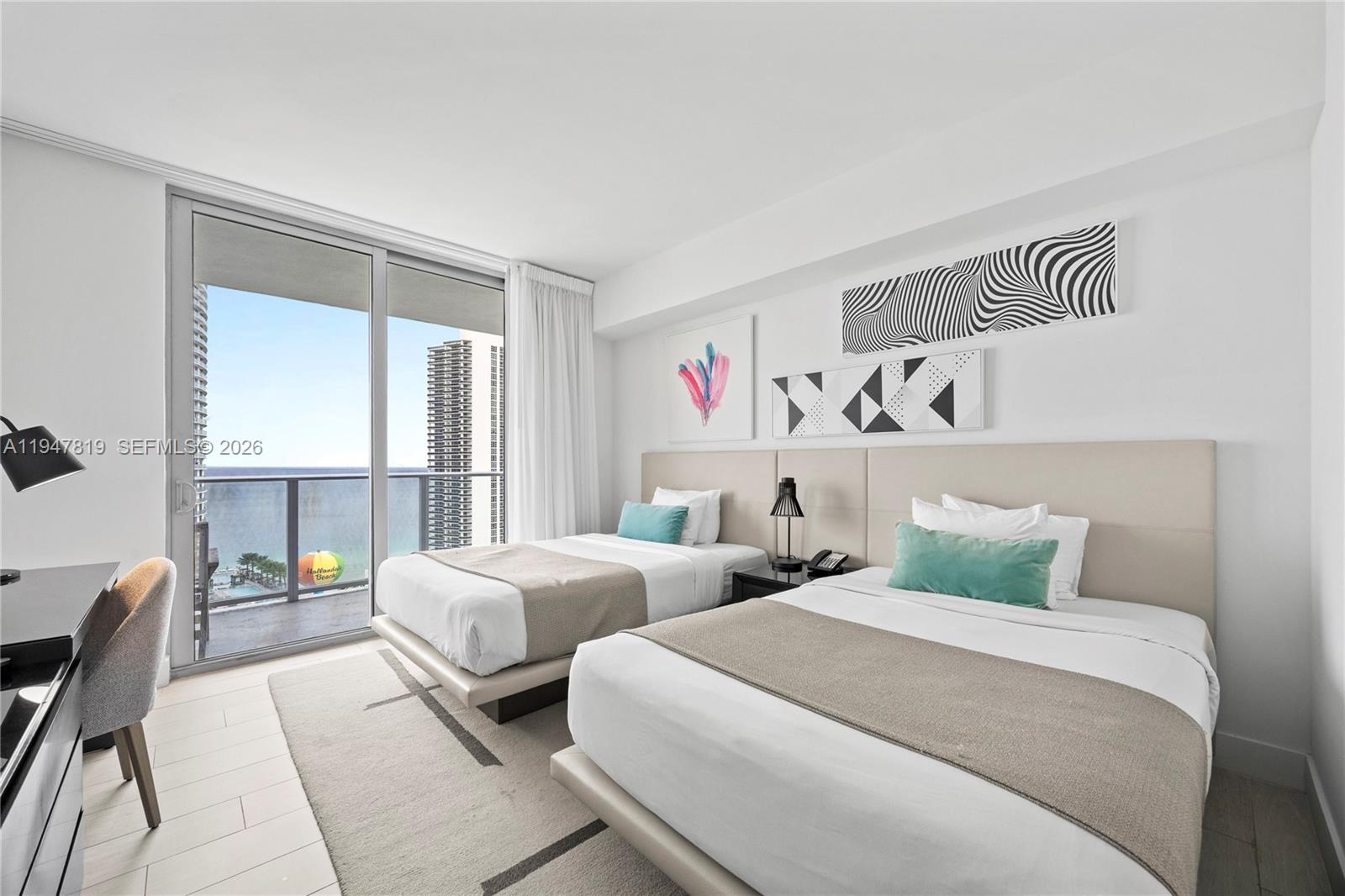 4010 South Ocean Drive, Unit R2307 Hollywood, FL 33019 - Photo 26 of 35 a bedroom with two beds and a large window