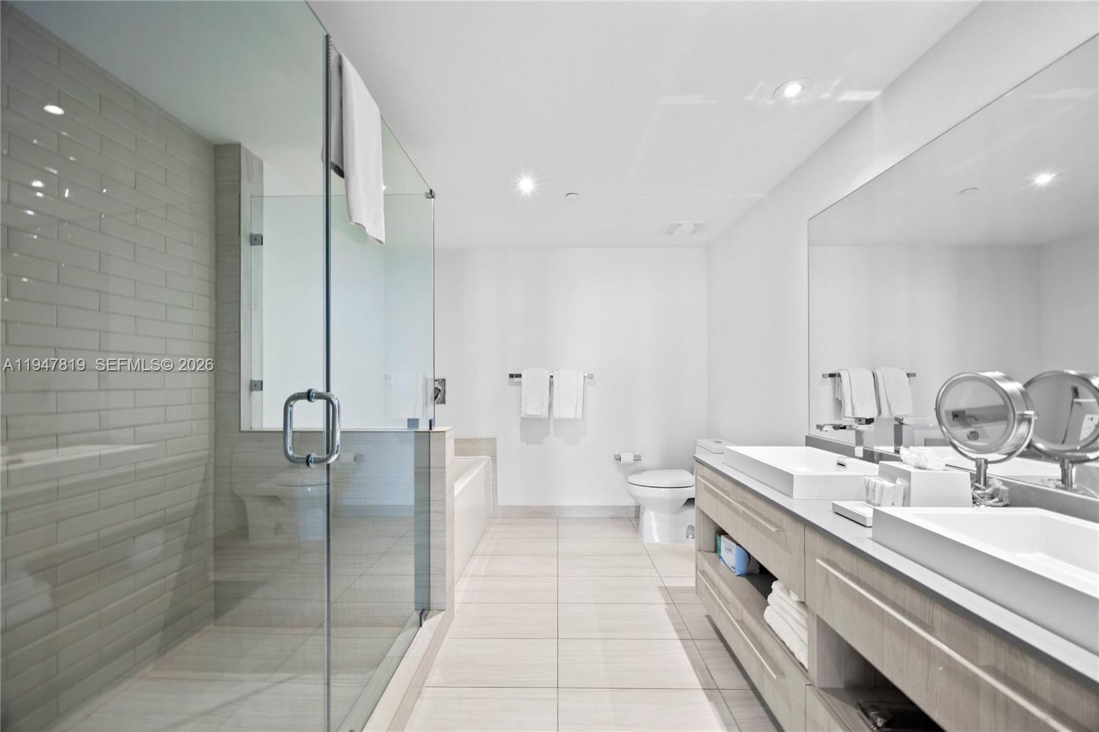 4010 South Ocean Drive, Unit R2307 Hollywood, FL 33019 - Photo 29 of 35 a bathroom with a double vanity sink a mirror and a shower