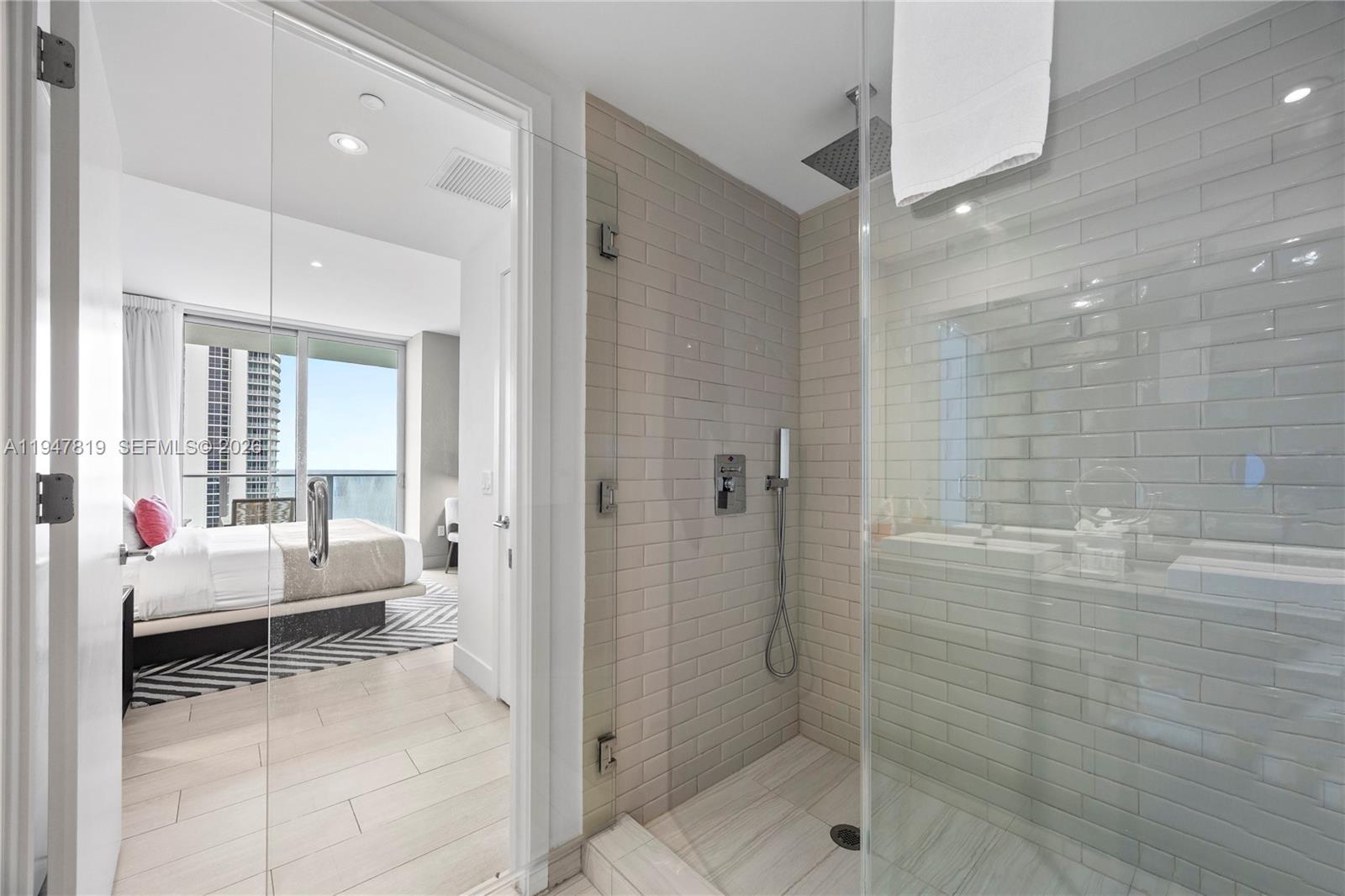 4010 South Ocean Drive, Unit R2307 Hollywood, FL 33019 - Photo 30 of 35 a bathroom with a tub shower and bedroom view