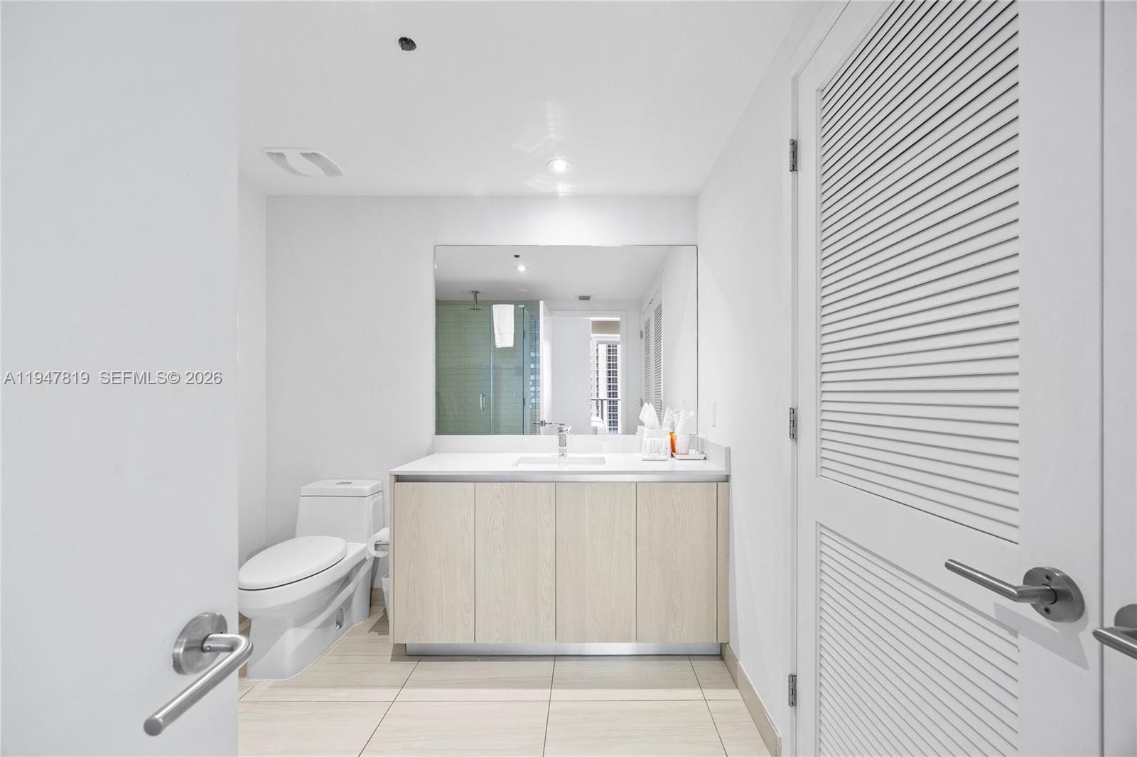 4010 South Ocean Drive, Unit R2307 Hollywood, FL 33019 - Photo 33 of 35 a bathroom with a sink a toilet and mirror