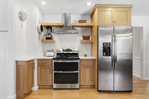 a kitchen with stainless steel appliances granite countertop a refrigerator and a stove